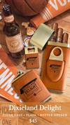Dixieland Delight leather items including a flask, cigar case, and bottle opener on a wooden surface with a beer bottle and newspaper.