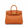 An orange pebbled leather handbag with gold-tone hardware, featuring dual top handles and a front strap closure, photographed against a solid white background.