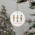 Round Christmas ornament with nutcrackers and 'Happy VOLidays' text, hanging on a tree.