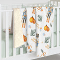 Crib with decorative blankets featuring holiday-themed patterns on a white background